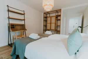 洛格罗尼奥Natural Stay Apartamentos PassivHaus的卧室配有白色的床和书架
