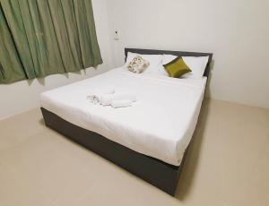 尖竹汶Phakdee Place的一张带白色床单和枕头的床