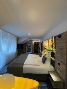 Heimbuchenthal克里斯特尔酒店的一间卧室设有一张大床和一张黄色的桌子。