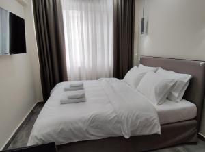 塞萨洛尼基MODIANO CENTRAL STUDIO的一间卧室配有带白色床单和枕头的床。