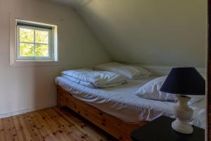 SundSharming cabin in Sund的一间卧室配有一张带灯和窗户的床