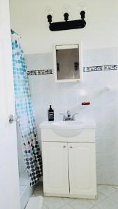 圣詹姆斯SugaLove Villa 30 Flamboyant Ave的白色的浴室设有水槽和镜子