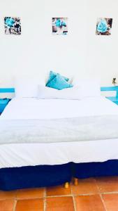 圣詹姆斯SugaLove Villa 30 Flamboyant Ave的一张带白色床单和蓝色枕头的床