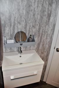 OccumsterThe Windy Roost的浴室设有白色水槽和镜子