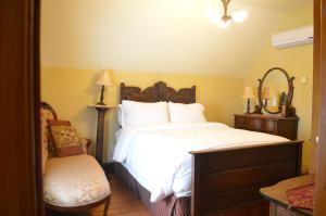 蒙克顿Magnetic Hill Winery的卧室配有一张白色大床和一把椅子