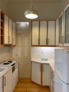 沃洛斯Anavros beach house的厨房配有白色橱柜和白色冰箱。