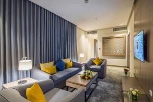 利雅德Erfad Hotel - Riyadh的客厅配有蓝色沙发和黄色枕头。