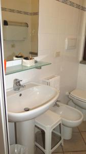 卡斯蒂里昂纳·德拉佩Residenza Turistico Alberghiera Corallo的白色的浴室设有水槽和卫生间。