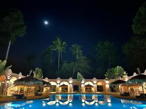 拉迈Zibá Home Suites的夜间带游泳池的度假村