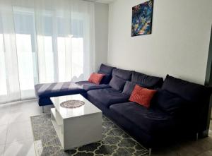 贝林佐拉GaLa Appartamento的客厅配有蓝色的沙发和桌子