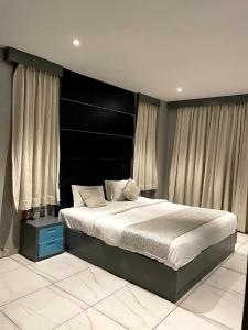 蓬蒂切里NT Hotels and Resorts Akridha的一间卧室配有一张大床和黑色床头板