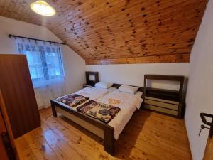 扎布利亚克Apartments Đurđić的一间卧室设有一张床和木制天花板
