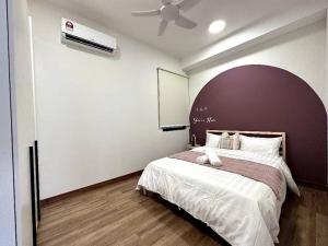 马六甲The Apple PREMIER CONDO three bedroom in MELAKA的一间卧室配有一张大床和吊扇