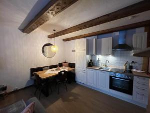 巴德小基希海姆阿尔彭豪斯公寓的厨房配有白色橱柜、餐桌和用餐室