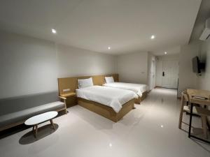 Tha ChangSuper Highway Hotel的一间卧室配有两张床,内设长凳