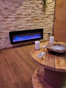 特鲁瓦Le Spa de la Cathédrale - Jacuzzi - Sauna - Champagne - Netflix - Wifi的客厅配有桌子和壁炉