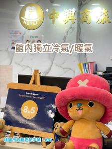 中坜中興商旅  的戴着粉红色帽子和盒子的泰迪熊