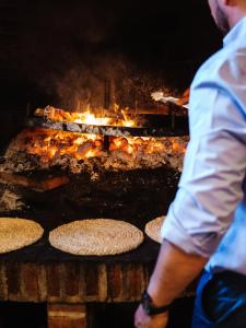 CasarejosPosada Real de Carreteros的一个人站在烧烤炉前吃着食物