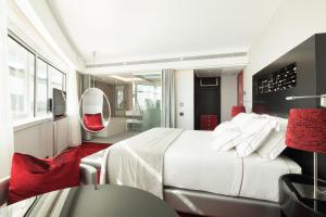 里斯本米瑞亚德SANA酒店的卧室配有白色的床和红色椅子