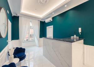 罗马SM Mellini Relais B&B的厨房拥有蓝色的墙壁,配有带蓝色椅子的柜台。