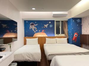 中坜中興商旅  的一间设有两张床和宇航员壁画的房间