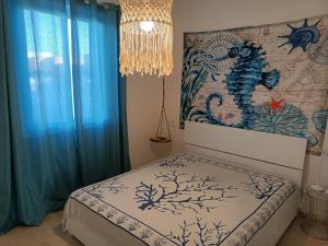 马尔扎梅米Villa Colapesce的一间卧室配有一张带蓝色窗帘和吊灯的床。