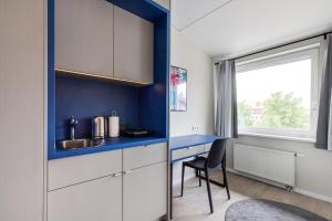 维尔纽斯Youston self check-in coliving Vilnius的厨房设有蓝色的墙壁和书桌。