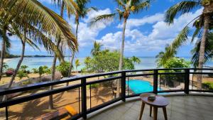 阿尔比恩La Maison de la plage的享有海滩和棕榈树景致的阳台