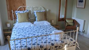 Saint-Cirgues-de-JordanneLa Maison Normande的一间卧室配有一张带蓝色和白色棉被的床