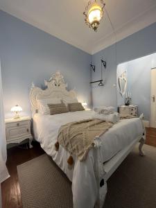波尔图Casinhas no Carolina - Hostel的卧室配有一张白色大床和吊灯。
