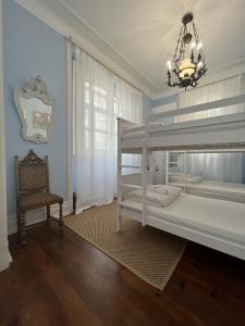波尔图Casinhas no Carolina - Hostel的卧室配有白色双层床和椅子