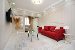 阿拉木图Уютная студия на Арбате的客厅配有红色的沙发和桌子