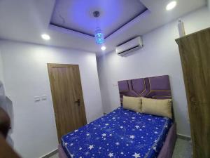 拉各斯Dinero Crystal - 2 Bedroo, Apartment的一间卧室配有一张带蓝色调和星光的床