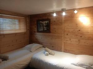 夏蒙尼-勃朗峰Three Bedroomed Chalet Apartment的木墙客房的两张床