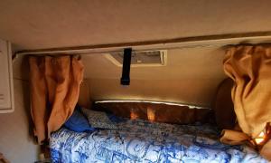 波尔蒂芒Rent a BlueClassics 's Campervan le Voyageur In Algarve au Portugal的露营车后面的一张床位