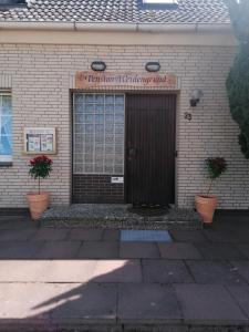 瓦尔斯罗德Pension Weidengrund的两棵植物的建筑物的前门