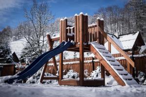 耶泽尔斯科Chata Eva的雪地中的木制游乐场,带滑梯