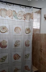 圣斐利-银港CASA BETTY COSTAMBAR的浴室内带贝壳的浴帘