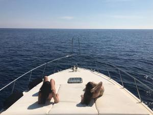 爱琴娜岛Motor yacht 45', 3 Cabins, 2 WC的两个女人躺在海上的船前