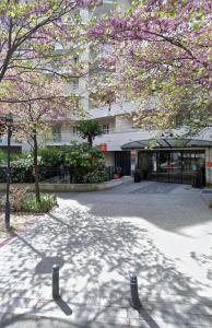 库尔布瓦Ryan Homes - in Apart hotel, La Défense的一座建筑物前有粉红色花的树