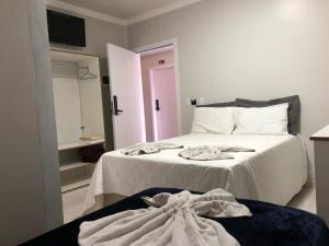 蓬塔波朗GUARANY HOTEL PONTA PORÃ的一间卧室配有带毛巾的床