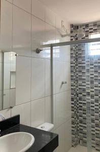 蒙蒂斯克拉鲁斯Apartamento inteiro 2 quartos Wi-Fi的一间带水槽和玻璃淋浴的浴室