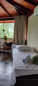 卡皮托利乌Pousada Jipe Canastra的卧室配有白色床和木制天花板