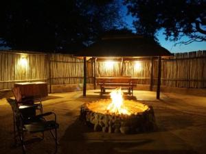 侯斯普瑞特Kum Kula Lodge的院子里的火坑,带长凳和桌子
