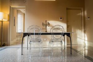 卢卡Noble Floor - Luxury Apartments的一间带两把椅子和一张桌子的用餐室