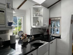 LlanfairBeautiful Cottage in Llanfair with ocean views的厨房配有黑色台面和水槽