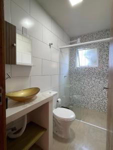 弗洛里亚诺波利斯Floripa Beach House Hostel的一间带水槽和卫生间的浴室以及窗户。