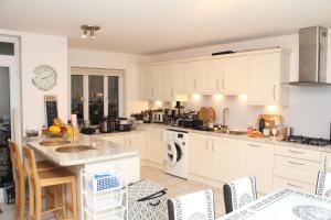 Spinney HillElegant Guest House的厨房配有白色橱柜和桌椅