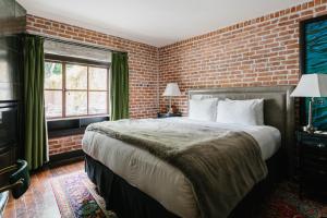 圣路易斯-奥比斯保格拉纳达酒店兼小酒馆的一间卧室设有一张大床和砖墙