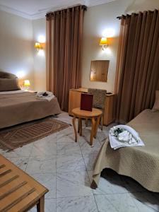 突尼斯HOTEL LAFAYETTE的酒店客房设有两张床和一张桌子。